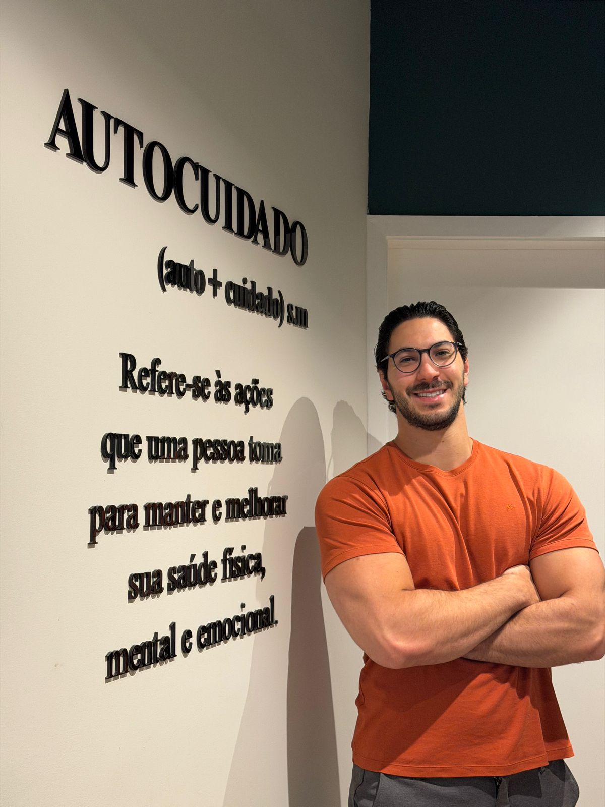 Rafael Lauand no consultório, em frente à parede Autocuidado